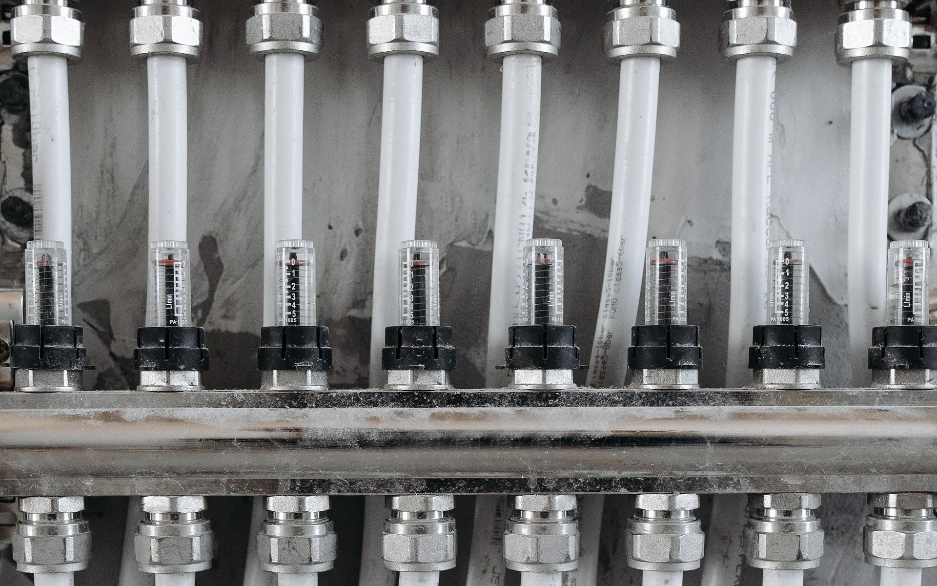 Hydraulischer Heizkreisverteiler mit Durchflussmessern und sauber verlegten Rohrleitungen.